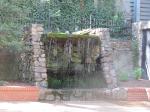 Waterfall between buildings in a park with a small stage